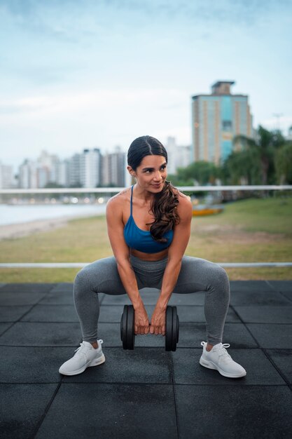 Allenamento donna in forma a tutto campo con manubri