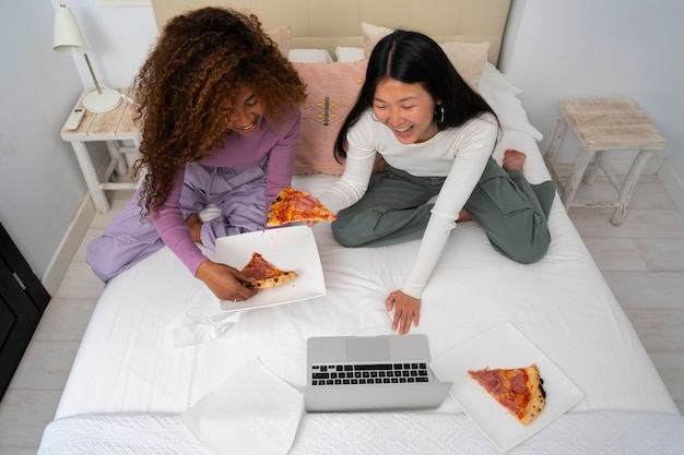 Full shot friends eating delicious pizza