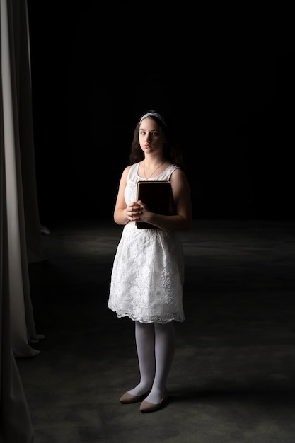 Full shot girl holding bible