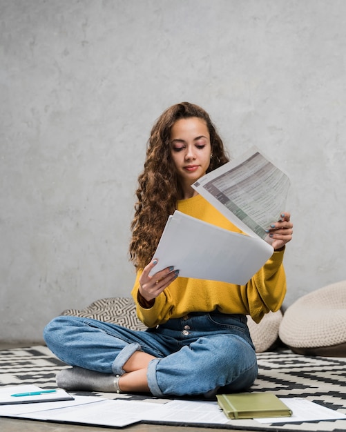 Foto ragazza della foto a figura intera che osserva sopra le sue note