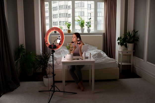 Full shot girl recording her makeup routine