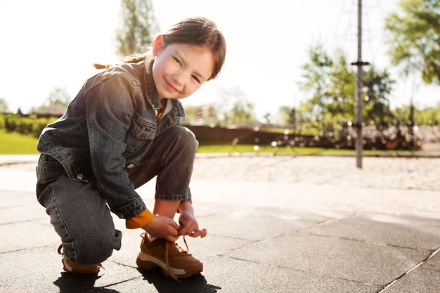 Photo full shot girl typing her shoelaces