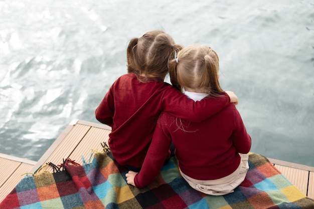 Full shot girls sitting at seaside