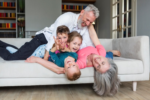 Photo full shot happy family playing on couch