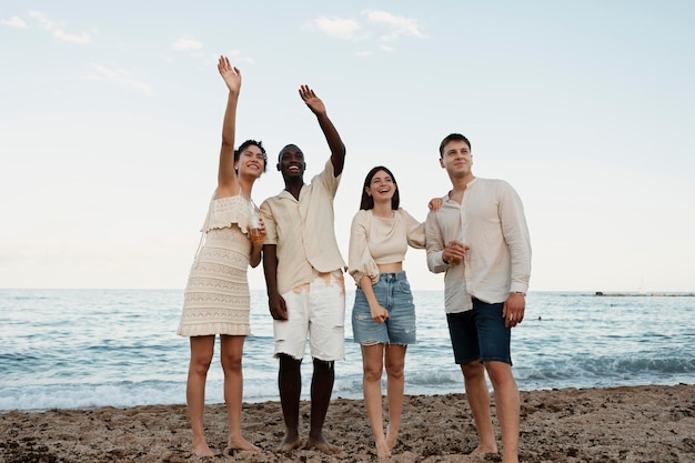 Foto amici felici a tutto campo in spiaggia