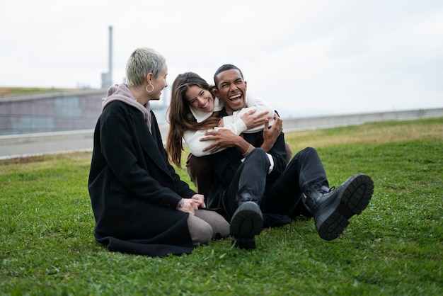 Photo full shot happy people sitting on grass