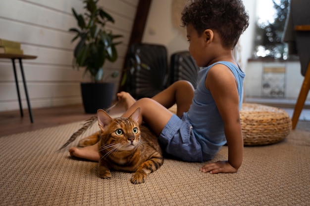 full shot kid and cat on floor
