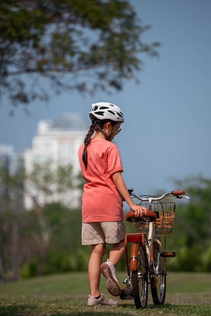 写真 フルショットの子供が屋外でサイクリング