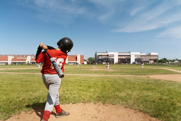 写真 野球のバットを持っているフルショットの子供