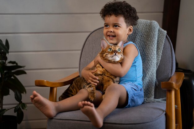 Foto ragazzo a tutto campo che tiene in braccio un gatto