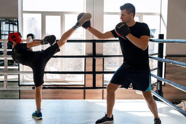 Foto ragazzo a tutto campo che impara la boxe