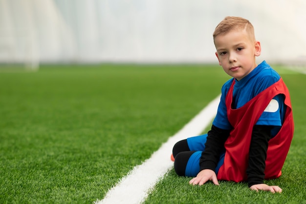 写真 草の上に座っているフルショットの子供