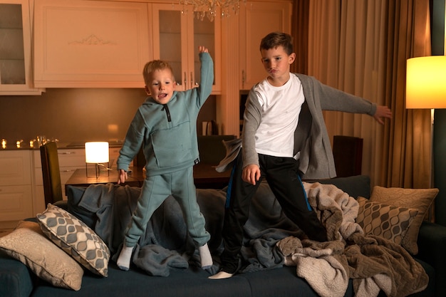 Photo full shot kids dancing on couch