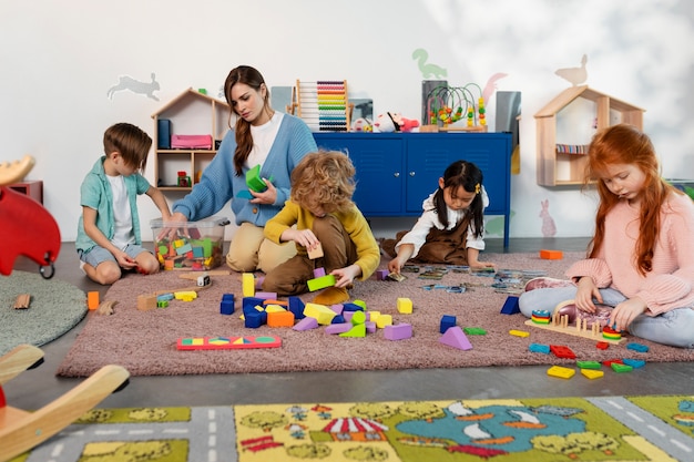 Foto bambini a tutto campo che giocano insieme sul pavimento