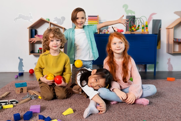 写真 幼稚園で一緒にポーズをとるフルショットの子供たち