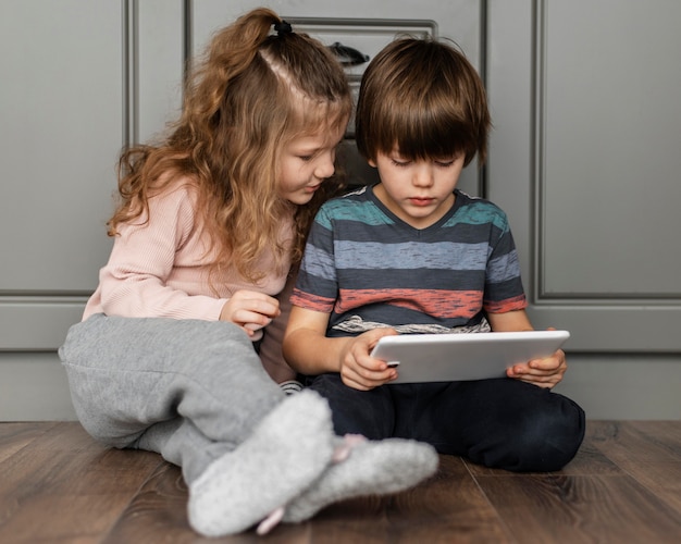 Full shot kinderen kijken naar tablet