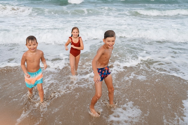 Foto bambini piccoli che si divertono in spiaggia