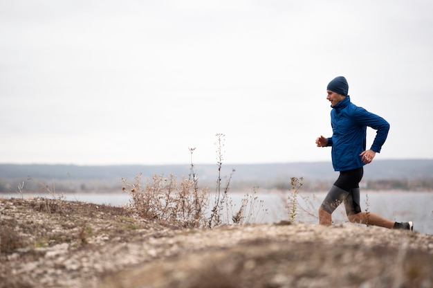 Full shot male running on trail