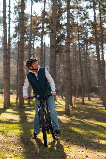 Foto uomo a figura intera in bicicletta all'aperto