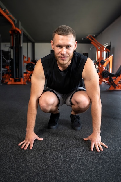 Uomo del colpo pieno che si esercita in palestra