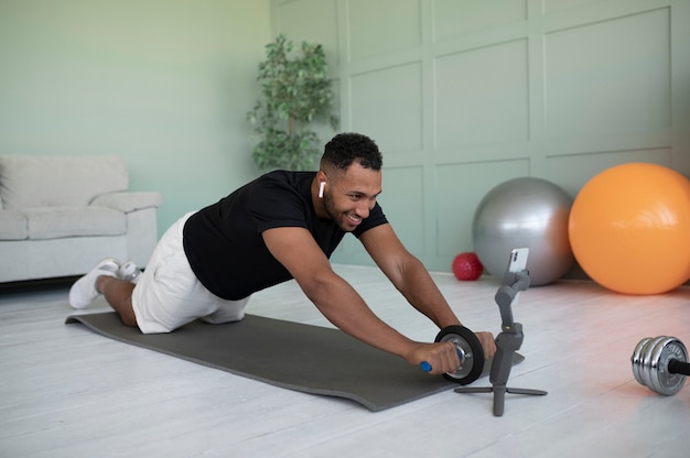 Full shot man exercising at home