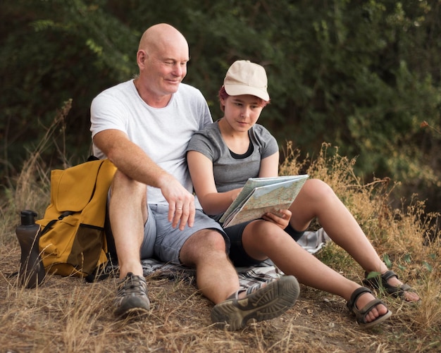 Full shot man and girl sitting on grass