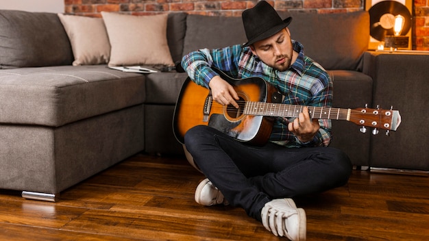 Foto uomo pieno del colpo che gioca la chitarra