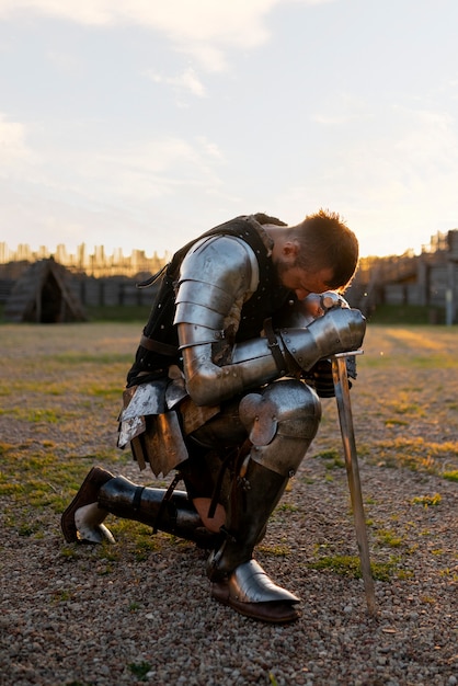 Full shot man posing as a medieval soldier