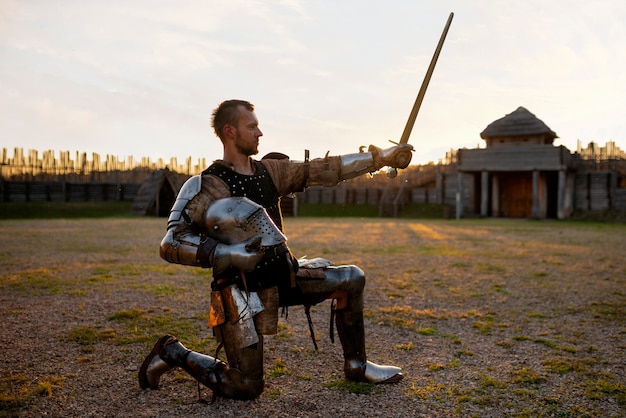 Full shot man posing as a medieval soldier