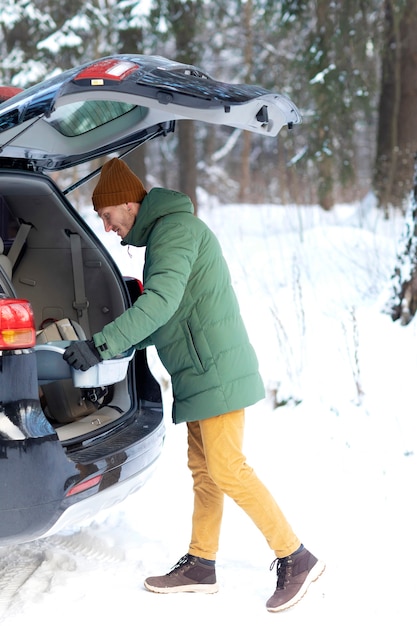 Photo full shot man putting item in car trunk