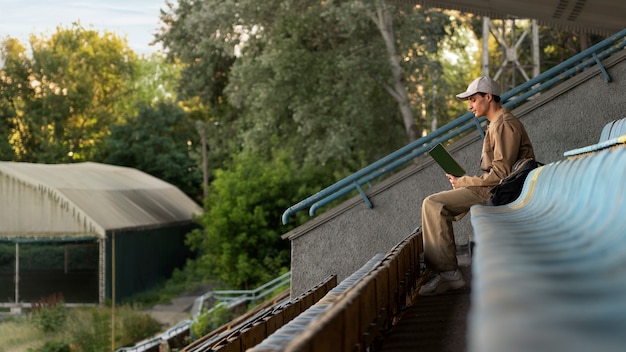 Full shot man reading in grandstands