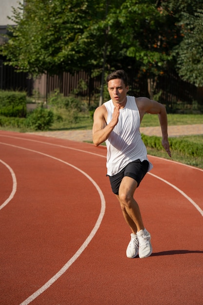 Uomo a tutto campo che corre in pista