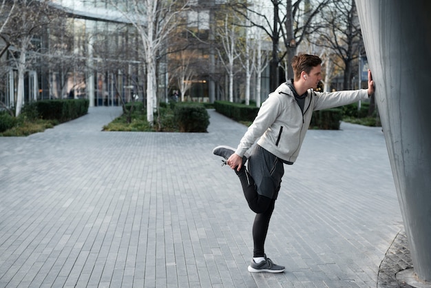 Full shot man stretching outdoors