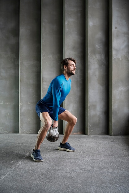 Foto allenamento uomo a tutto campo con kettlebell