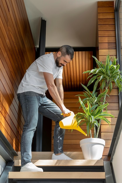 Photo full shot man watering plant