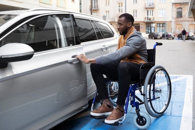 Photo full shot man in wheelchair with car