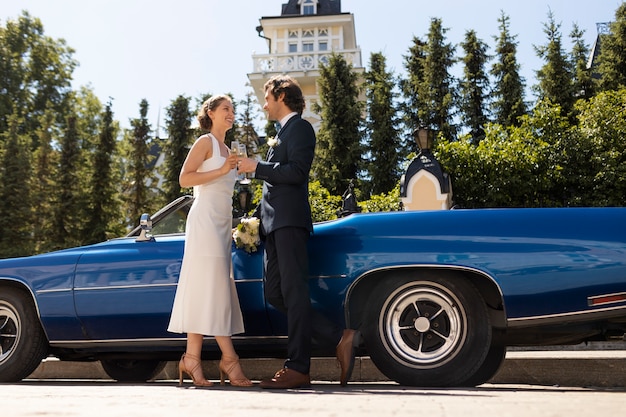 Full shot married couple with car