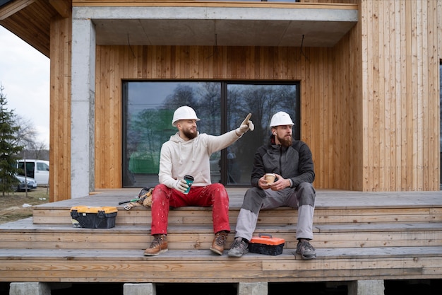 Foto uomini a tutto campo che chiacchierano al lavoro