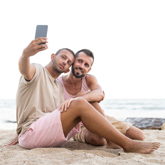 Full shot men taking selfie