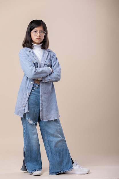 Full shot of Mexican young girl arms crossed serious face wearing blue jeans