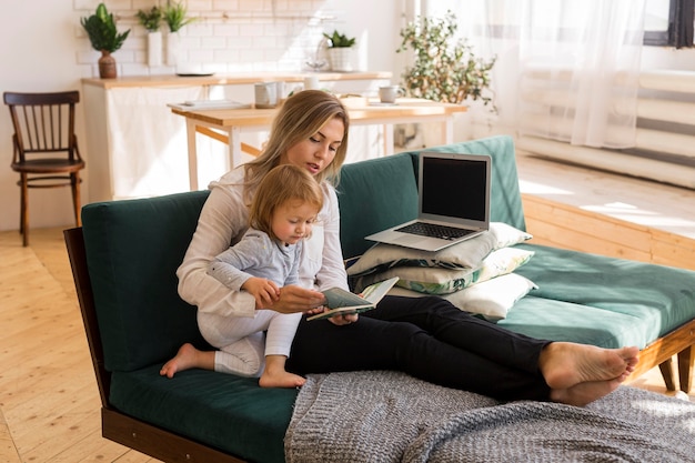 Full shot mother reading to kid