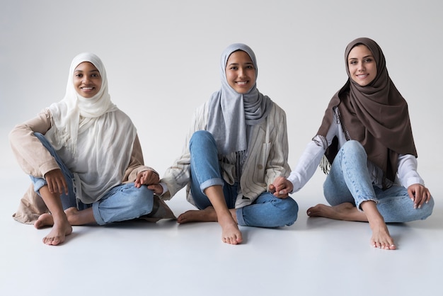 Full shot muslim women holding hands