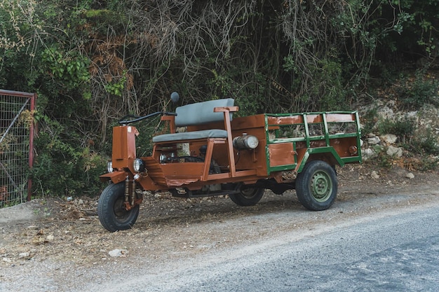 Full shot of an old vehicle stopped on the side of a road