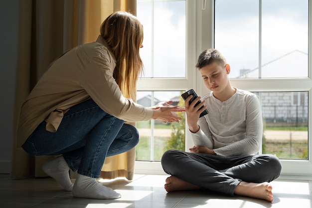 Genitore a tutto campo che prende il telefono dal bambino