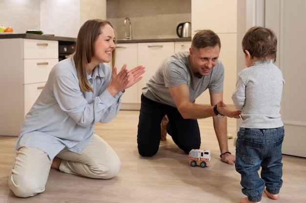 Photo full shot parents watching kid's first step