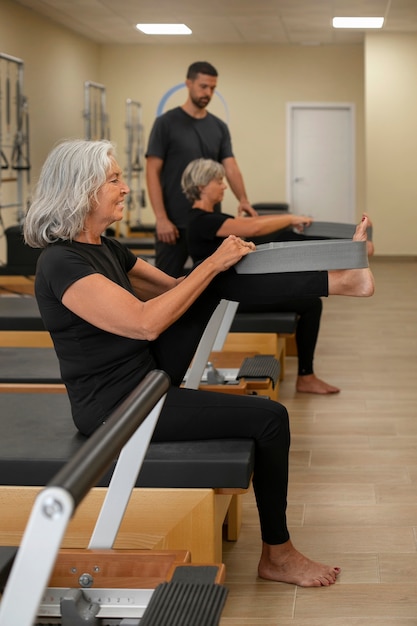 Foto persone in piena ripresa in lezione di pilates