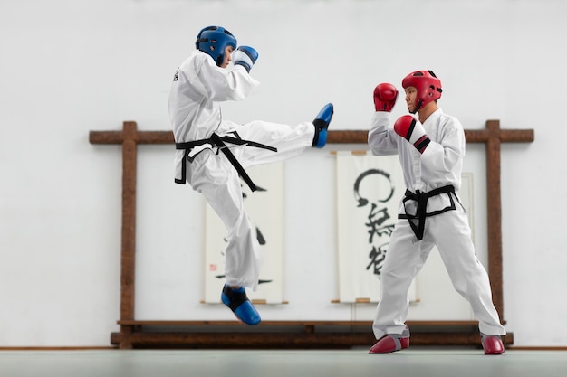 Foto persone a tutto campo che praticano il taekwondo