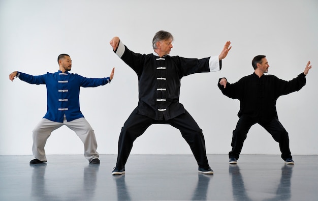 Foto persone a tutto campo che praticano il tai chi