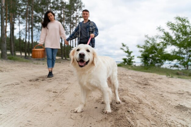 Full shot people walking with dog outdoors