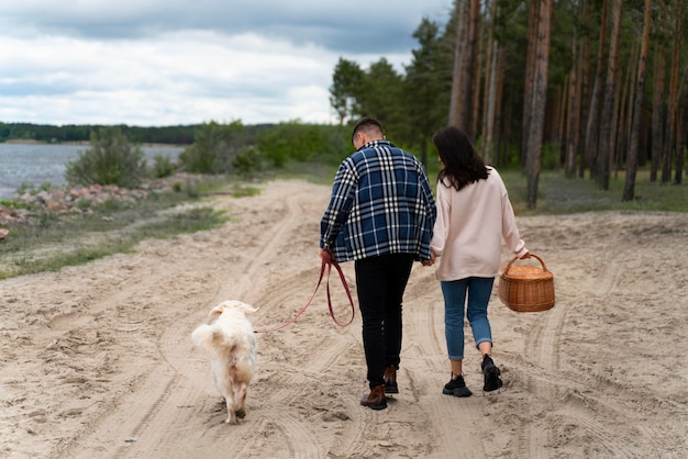 写真 ビーチで犬と一緒にフルショットの人々